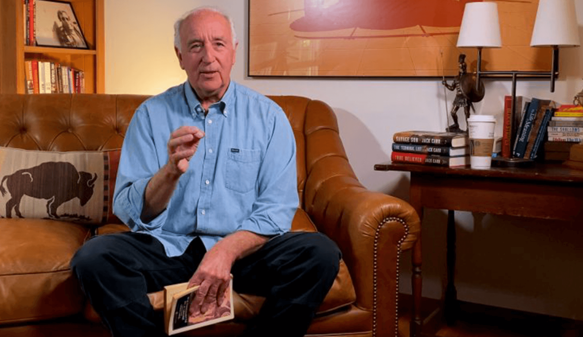 Steve Pressfield sitting on a couch reading a book